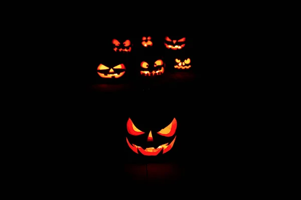 Koncept Halloween. Mnoho Zářící ohnivé světlo zlobí strašidelné dýně — Stock fotografie