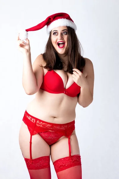 Glücklich niedlichen fetten Weihnachtsmann Mädchen. Model in roter Dessous und Weihnachtsmütze. — Stockfoto