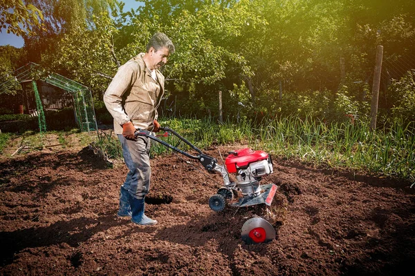 Farmář pluhy půdy s kultivátor, příprava na vý — Stock fotografie