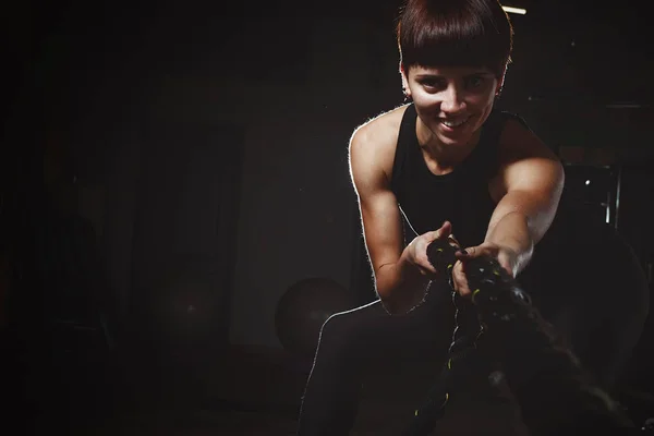 Chica de fitness haciendo ejercicios de crossfit en el gimnasio con cuerda grande en da —  Fotos de Stock