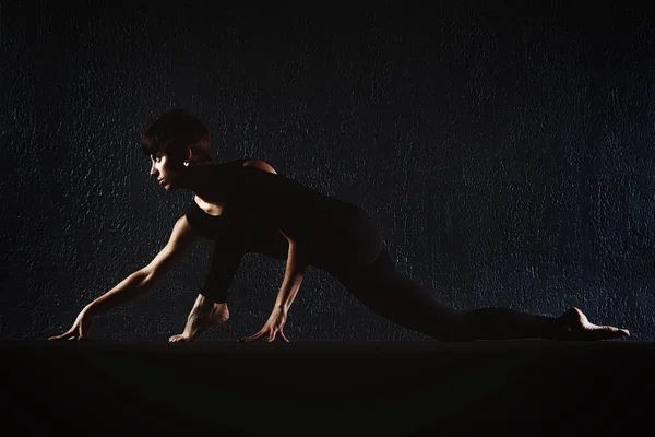 Γυμναστήριο κορίτσι κάνει crossfit ασκήσεις στο γυμναστήριο γιόγκα θέτουν σε σκούρο h — Φωτογραφία Αρχείου