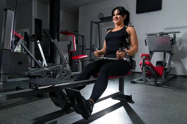 Donna plus size in palestra facendo esercizi con l'apparato di allenamento , — Foto Stock