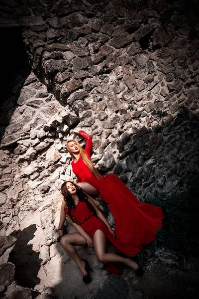 긴 다리를 가진 오래 된 바위 성곽에 포즈 빨간 드레스에 섹시 한 여자 — 스톡 사진