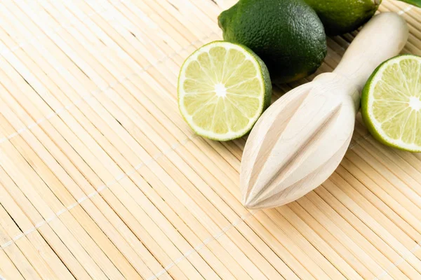 Healthy food and vitamins: a wooden juicer and fresh lime with l — Stock Photo, Image