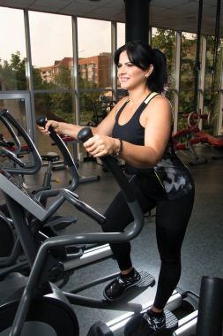 Kadın artı boyutu ile eğitim app koşma egzersizleri yapıyor spor salonunda