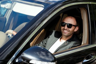 Siyah araba takım elbiseli şık adam. İş adamı sittin gözlük