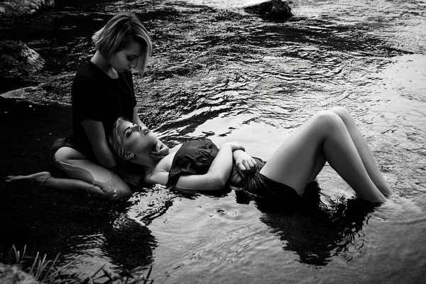 Ковані сексуальні дівчата в сукнях, пристрасно позують у воді, е — стокове фото