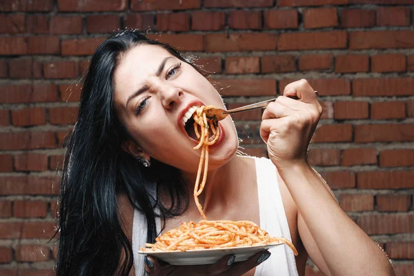 Sexy verführerisches Mädchen im weißen T-Shirt mit Teller Pasta und Tee — Stockfoto