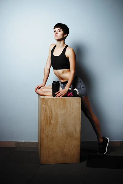 Chica fitness haciendo ejercicios en el gimnasio yoga pose en la sala de madera —  Fotos de Stock
