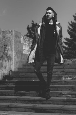 Oldukça ciddi genç adam sokakta. Rahat yaşam tarzı kıyafetler