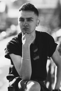 Oldukça ciddi genç adam sokakta. Rahat yaşam tarzı kıyafetler