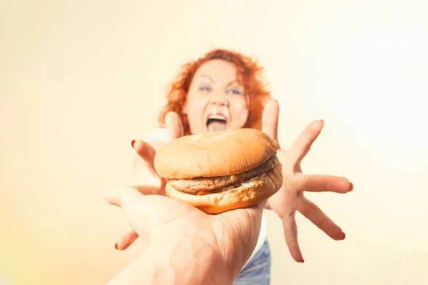 Mulher grande comer fast food. Menina gorda de cabelo vermelho com hambúrguer. Insalubre — Fotografia de Stock