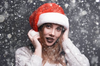 Beyaz kazaklı ve Noel Baba şapkalı güzel bir kız..