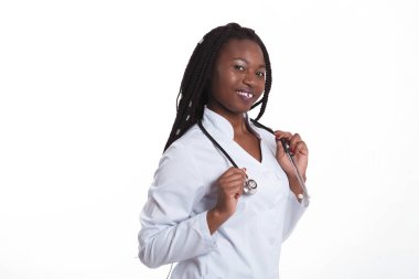 Kadın Amerikalı Afrikalı doktor, steteskoplu hemşire kadın. Başarılı olduğu için mutlu. Arka planda poz veren tıp çalışanı yalnız.