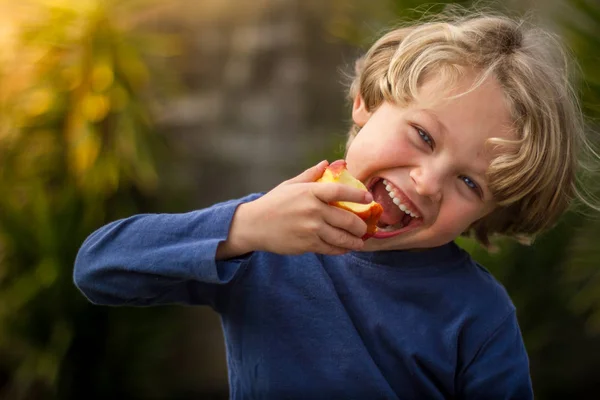 Niño de 5 años comiendo una manzana —  Fotos de Stock