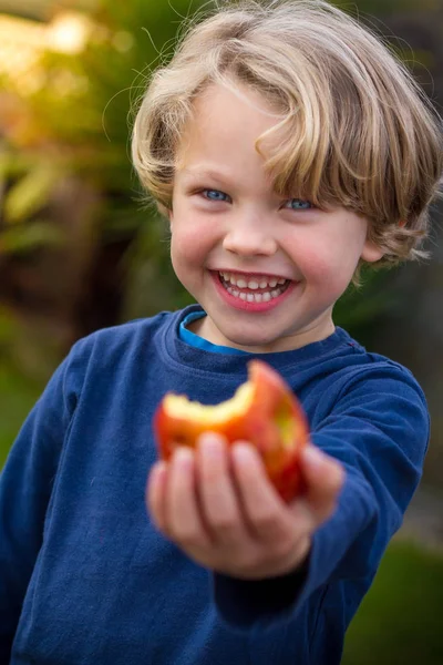 Lindo niño de 5 años comiendo una manzana —  Fotos de Stock