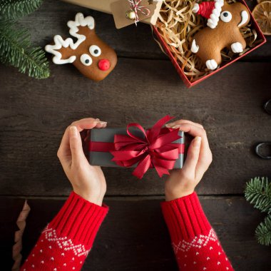 Kırmızı kurdele ile Noel hediyesi elinde tutan kadın. Xmas kavramı. 