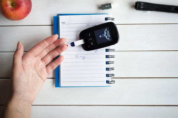 Woman checking sugar level with glucometer. Diabetes test.