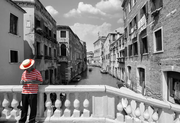 Puente blanco y negro sobre un canal en Venecia, con color rojo selectivo en la camisa a rayas de un gondolero — Foto de Stock