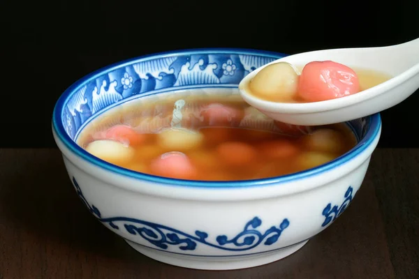 Bowl of sweet Chinese tangyuan dessert being eaten with a spoon — Stock Photo, Image