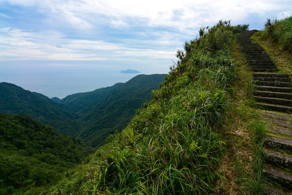 Passos ao longo de um cume íngreme na trilha histórica Caoling em Taiwan, com Turtle Island no fundo — Fotografia de Stock