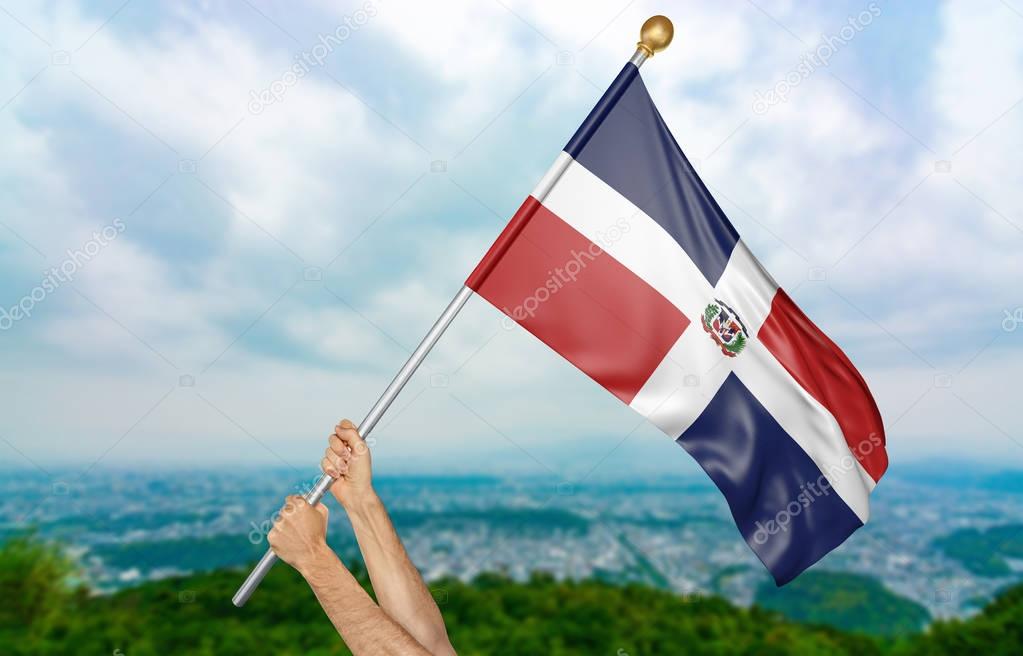 Young man's hands proudly waving the Dominican Republic national flag in the sky, part 3D rendering