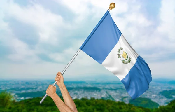 Manos de hombre joven ondeando orgullosamente la bandera nacional de Guatemala en el cielo, parte 3D representación — Foto de Stock