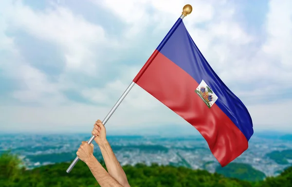Las manos de un joven ondeando orgullosamente la bandera nacional de Haití en el cielo, en parte representación 3D — Foto de Stock