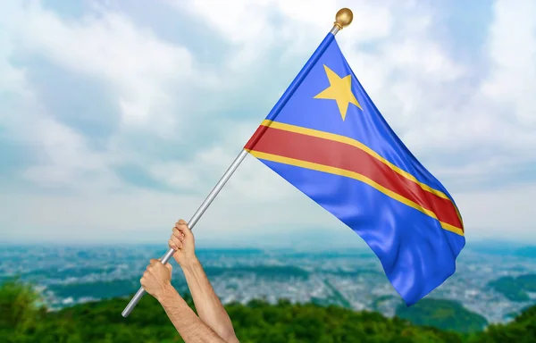 Manos de hombre joven orgullosamente ondeando la bandera nacional de la República Democrática del Congo en el cielo, parte 3D representación —  Fotos de Stock