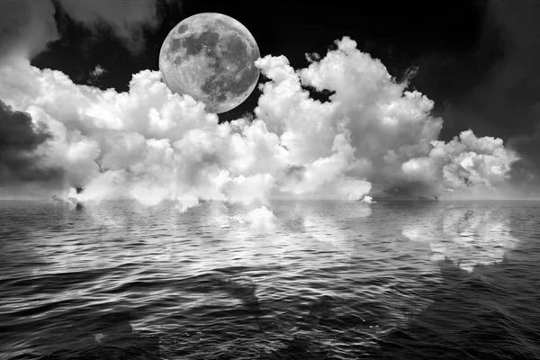 Vollmond und Wolken im dunklen Fantasie-Nachthimmel, der sich in welligem Ozeanwasser spiegelt — Stockfoto