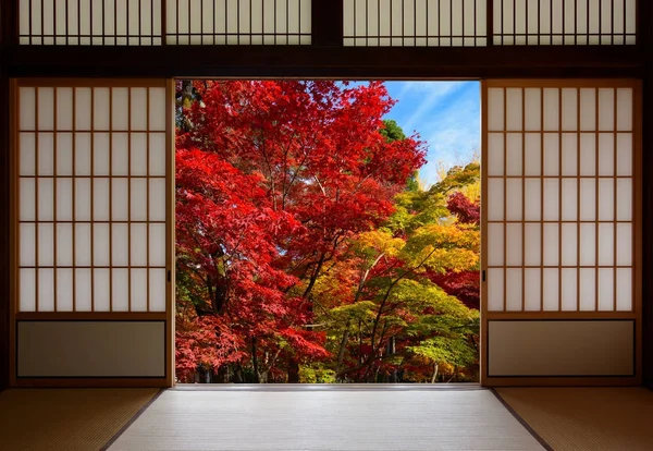 Japanese rice paper wood doors opened to an autumn forest with red and yellow fall colors