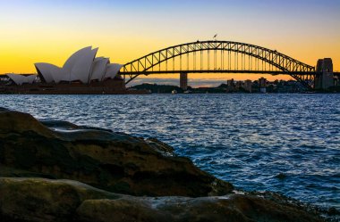 Sydney, Avustralya - 10 Mart 2018 - Sydney Opera Binası ve Harbour Bridge, doğal kıyı günbatımında gördün kentin ikonik simgesel yapılar