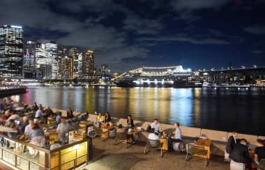 Sydney, Avustralya - 7 Mart 2018 - arkadaşları ve turistler bir yolcu gemisi önünde canlı Sydney gece hayatı zevk Circular Quay içinde demirli
