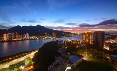 Romantik gün batımı ve Tayvan 'ın New Taipei şehrindeki Tamsui Nehri boyunca renkli şehir ışıkları