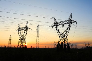 Akşamları, yüksek voltaj kulelerinin silueti