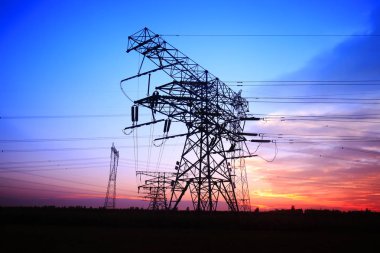 Akşamları, yüksek voltaj kulelerinin silueti