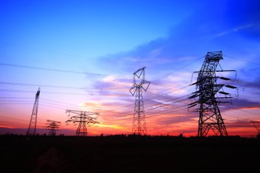 Akşamları, yüksek voltaj kulelerinin silueti