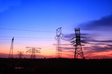 Akşamları, yüksek voltaj kulelerinin silueti