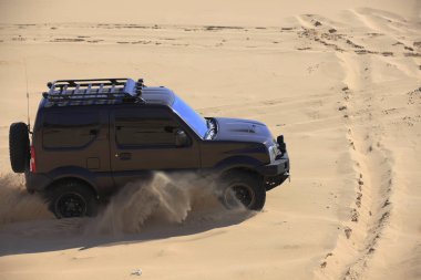 Çölde bir cip sürüyordu..