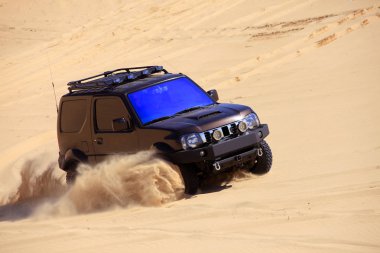 Çölde bir cip sürüyordu.