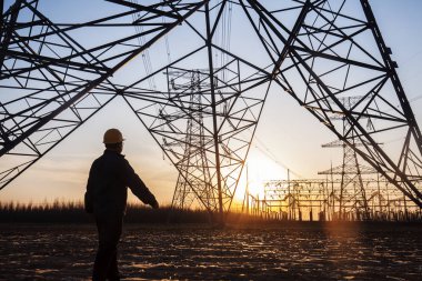 Elektrik işçileri ve pilon silueti
