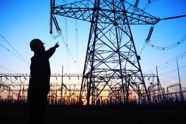 Elektrik işçileri ve pilon silueti