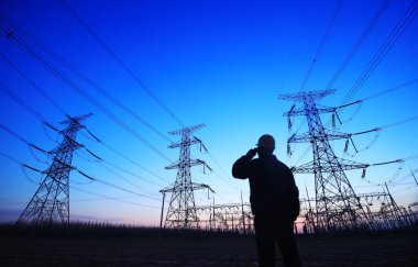 Elektrik işçileri ve pilon silueti