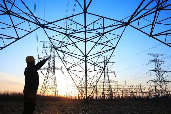 Electricity workers and pylon silhouette — Stock Photo, Image