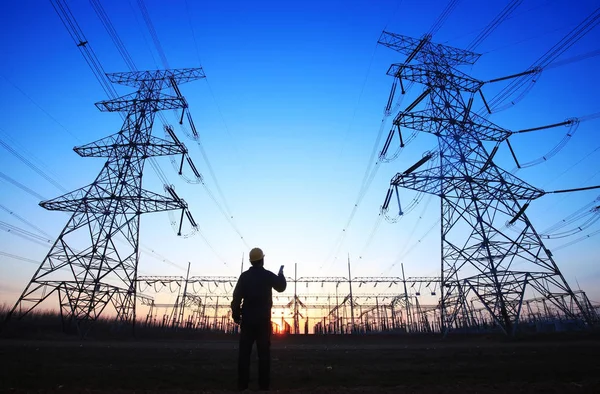 electricity workers and pylon silhouette