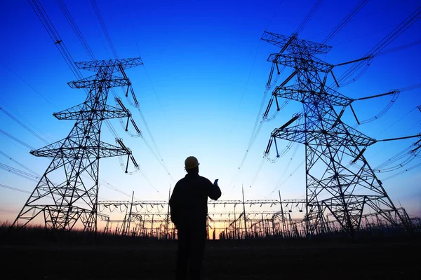 electricity workers and pylon silhouette