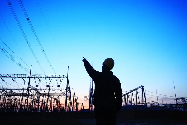 Electricity workers and pylon silhouette — Stock Photo, Image