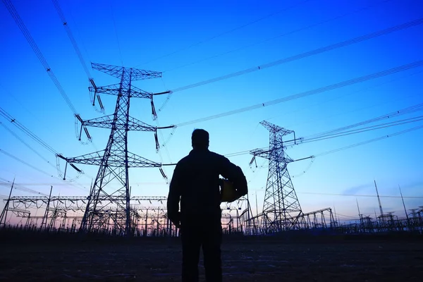 Elektrik işçileri ve pilon silueti