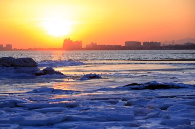 Kışın deniz kenarında gün batımı