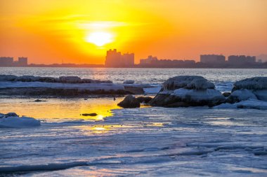 Kışın deniz kenarında gün batımı